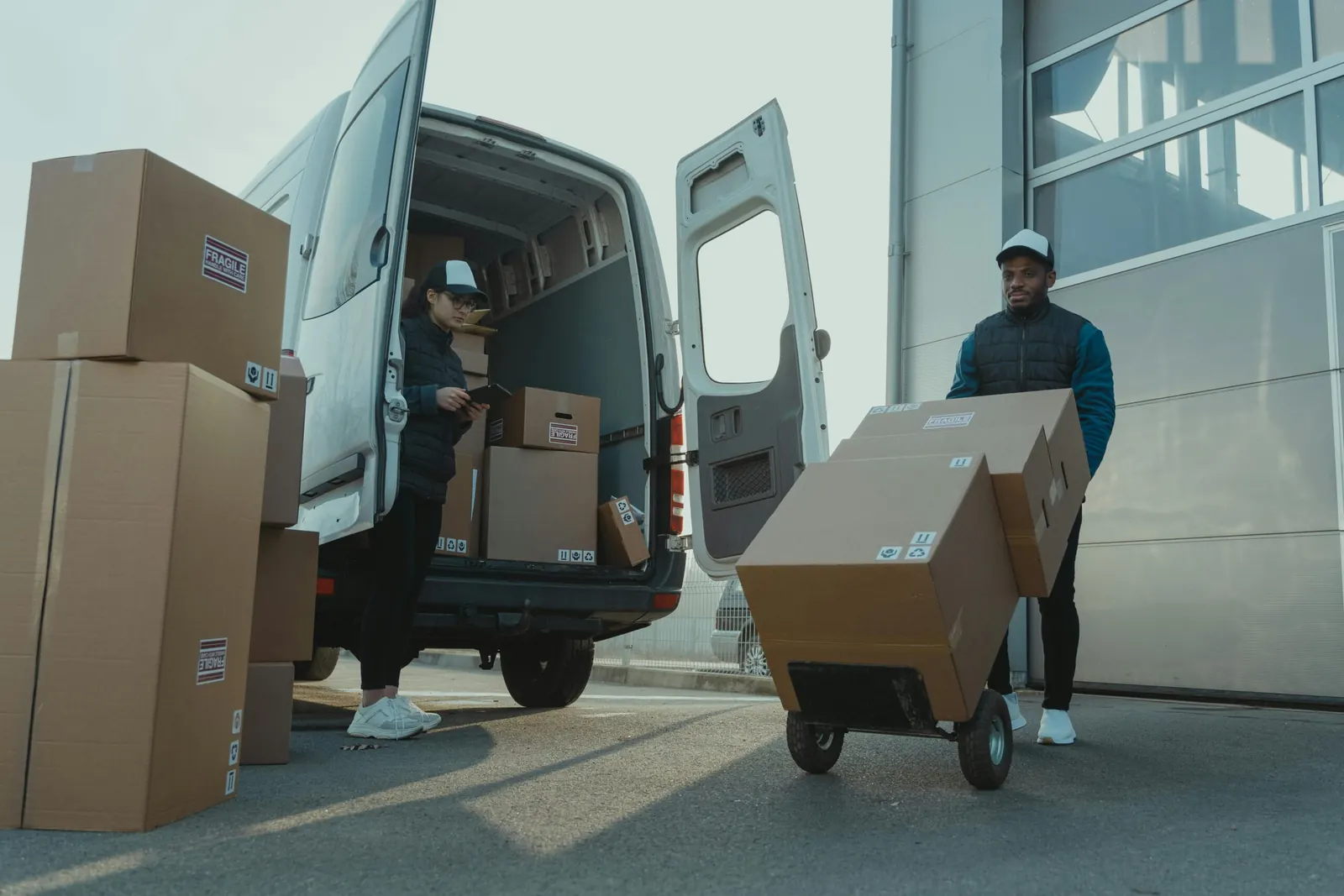 Courier unloading parcels from a van for last-mile delivery